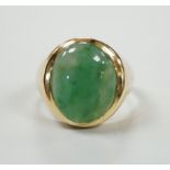 A modern 18ct gold and cabochon oval jade set ring, size P, gross weight 7.1 grams.