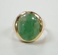 A modern 18ct gold and cabochon oval jade set ring, size P, gross weight 7.1 grams.
