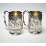 A pair of late 19th/early 20th century Chinese engraved white metal mugs, maker CS, height 13.5cm,