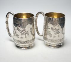 A pair of late 19th/early 20th century Chinese engraved white metal mugs, maker CS, height 13.5cm,