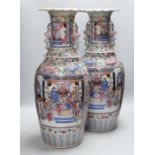 A pair of large Chinese porcelain famille rose vases, 19th century, decorated with court scenes