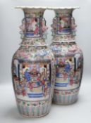 A pair of large Chinese porcelain famille rose vases, 19th century, decorated with court scenes
