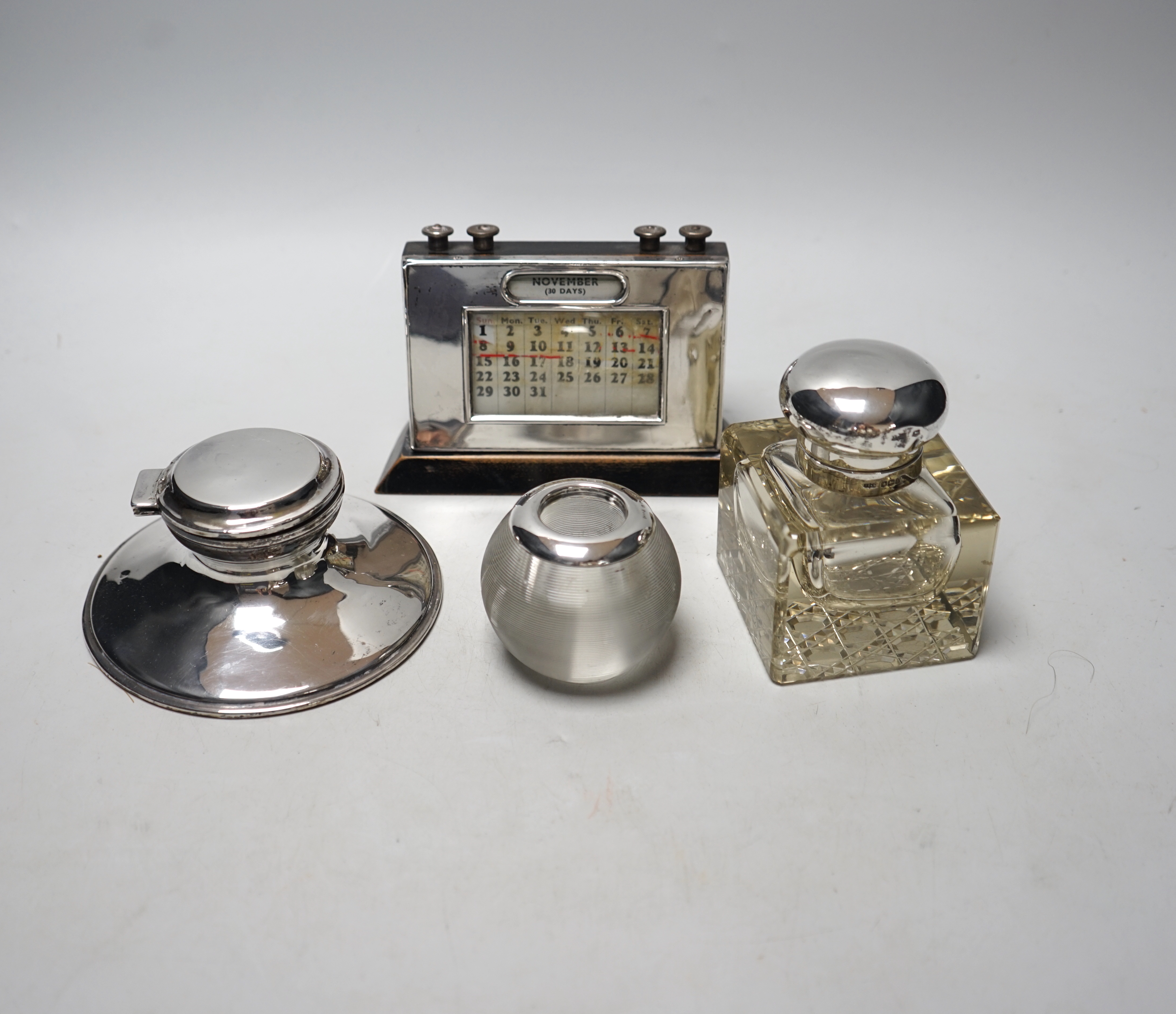 Two silver mounted inkwells, including capstan, a silver mounted desk calendar and a silver
