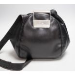 A Nina Ricci black leather shoulder bag with large metal clasp, engraved Nina Ricci, circa 1970's,