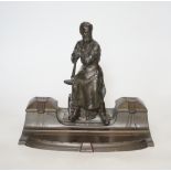 A WMF style spelter ‘Industry’ inkstand, figure with tools and an anvil, hinged ink wells either