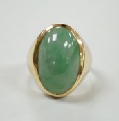 A modern 18ct gold and cabochon oval jade set ring, size P, gross weight 8.8 grams.