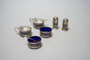 A George V pierced silver six piece condiment set, with blue glass liners, Gorham Manufacturing