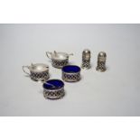 A George V pierced silver six piece condiment set, with blue glass liners, Gorham Manufacturing