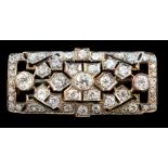 An early 20th century pierced gold and graduated round cut diamond cluster set brooch, of