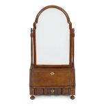 A Queen Anne walnut toilet mirror with arched bevelled plate, fitted interior and serpentine base
