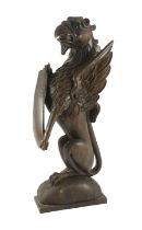 A 16th century Dutch carved oak model of a griffin rampant holding a shield, on domed base, 23cm