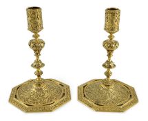 An ornate pair of Victorian silver gilt dwarf candlesticks, by John Wilmin Figg, with foliate scroll