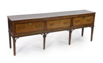A mid 18th century oak dresser base, with three long drawers, on squared cabriole legs, 225cm