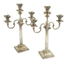 A matched pair of late 19th/early 20th century silver two branch, three light candelabrum, with