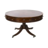 A Regency mahogany drum top library table, the circular top with burgundy leather skiver, four