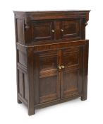 A 17th century oak court cupboard with moulded top and two panelled doors over two further