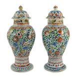 A pair of Chinese wucai spiral lobed baluster vases and covers, Kangxi, c.1680, each painted with