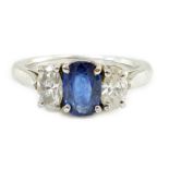 A modern platinum, singe stone oval cut sapphire and two stone oval cut diamond set ring, the