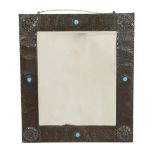 A Liberty & Co. Arts & Crafts planished copper wall mirror decorated with stylised Tudor roses to