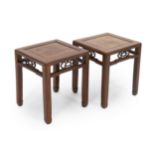 A pair of Chinese hongmu square stands, 19th century, the panelled and framed tops above shaped