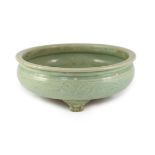 A large Chinese Longquan celadon ‘magnolia’ tripod censer, Ming dynasty, the compressed globular