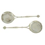 A pair of George V Asprey & Co pierced silver serving spoons, with dolphin handles and circular