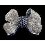 A modern white gold and pave set diamond and sapphire set ribbon bow brooch, set with round cut