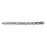 An early to mid 20th century platinum, moonstone and diamond cluster bracelet, set with ten cabochon