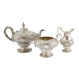 A Victorian silver inverted pear shaped three piece tea set by John Wellby, with embossed foliate