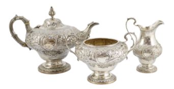A Victorian silver inverted pear shaped three piece tea set by John Wellby, with embossed foliate