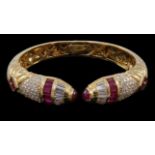 A modern 18ct gold, ruby and diamond cluster openwork hinged bangle, with serpent head style