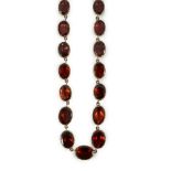 An early 19th century gold mounted graduated foil backed oval cut garnet set choker necklace,