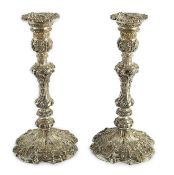 An ornate pair of Edwardian silver candlesticks, by Walker & Hall, with fixed sconces, waisted