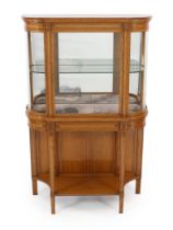 An Edwardian inlaid satinwood display cabinet of D shaped form with central glazed door over an