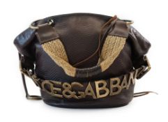 A Dolce & Gabbana brown and black leather bucket bag, two plaited fabric and leather handles with