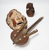 Two African tribal masks, a carved gourd vessel, four wood carvings and an instrument, tallest