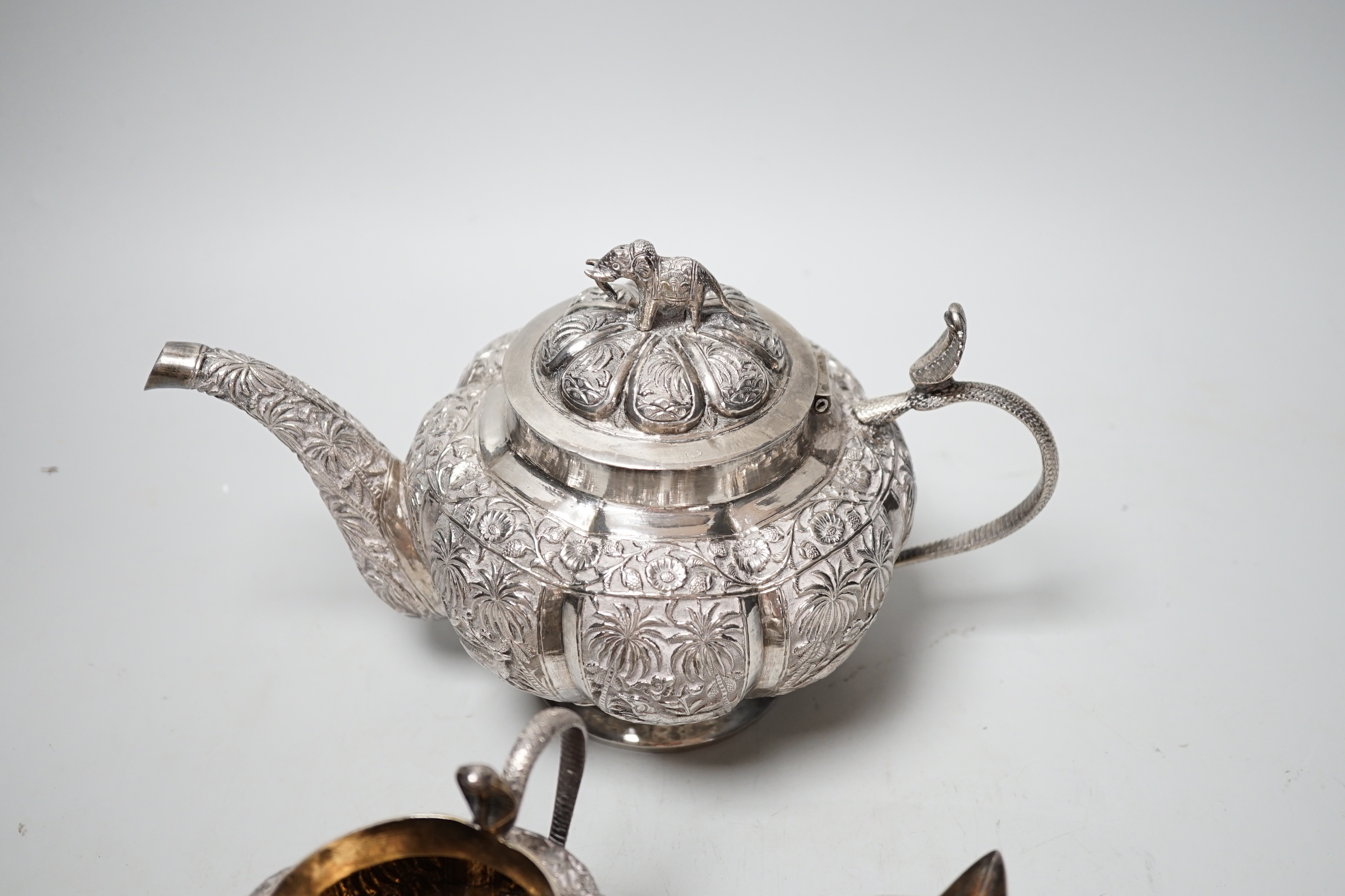 An Indian embossed white metal three piece tea set, with cobra handles and elephant finial, 25. - Image 5 of 5