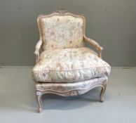 A Louis XV style bleached framed fauteuil, with floral upholstery and feather filled cushion seat,