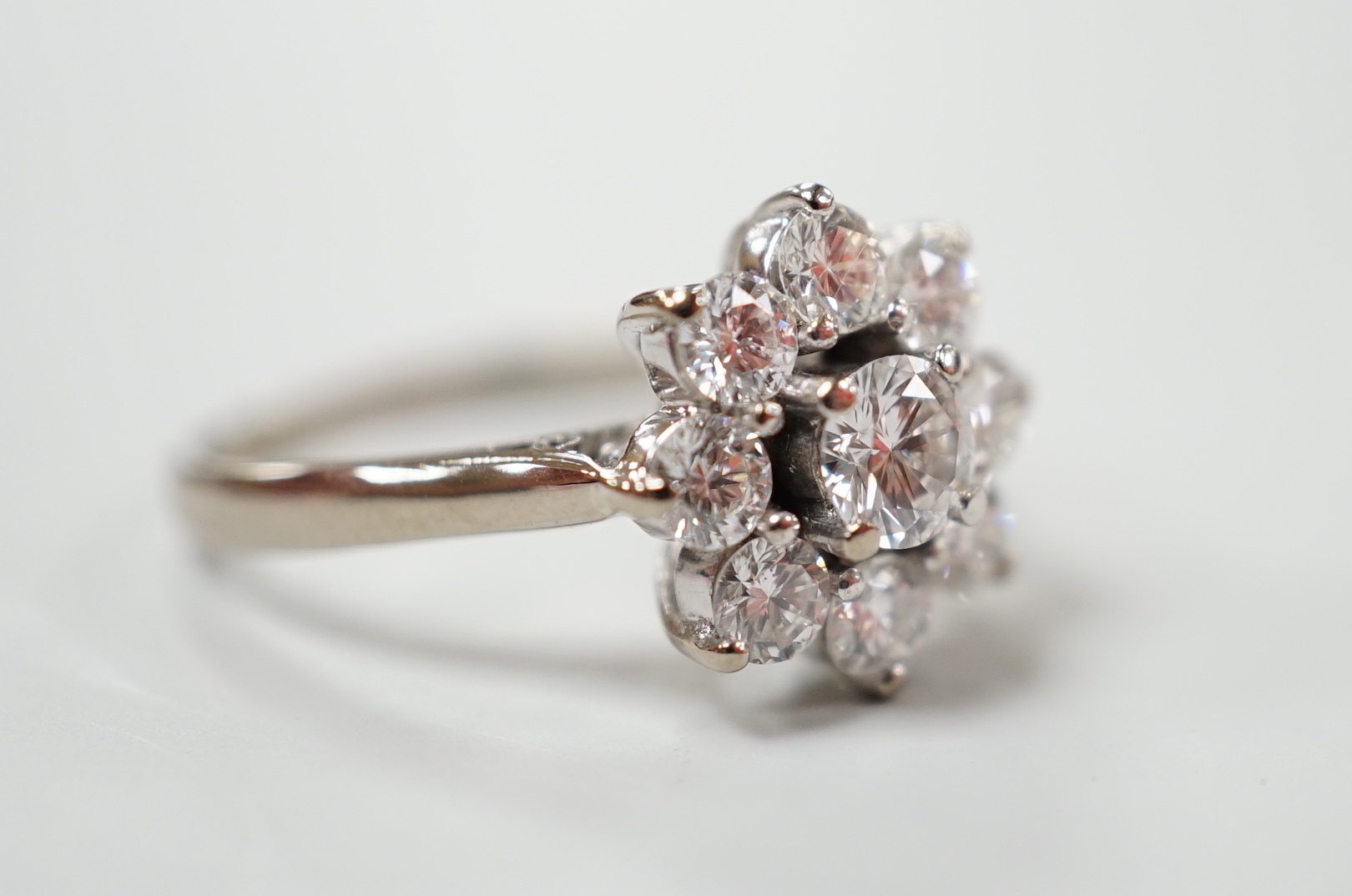 An 18ct, plat. and nine stone diamond set flower head cluster ring, the central stone weighing - Image 3 of 4