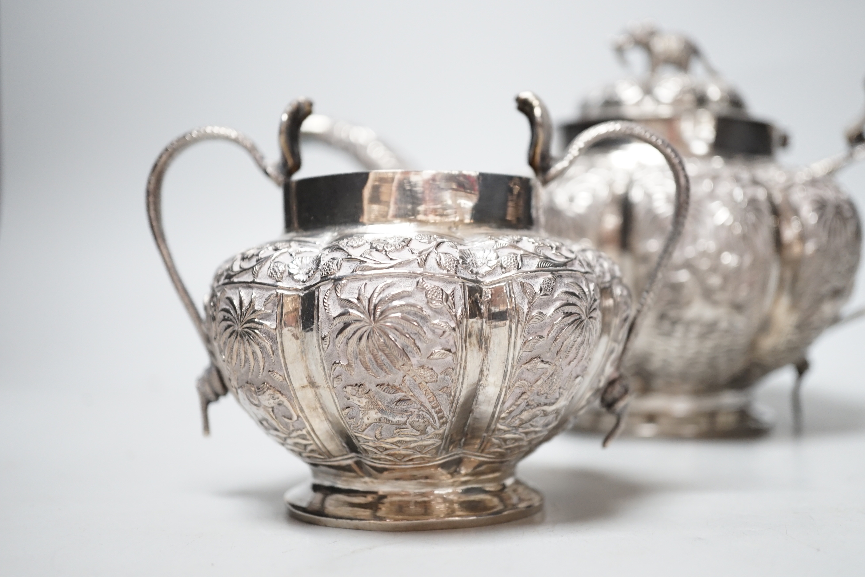 An Indian embossed white metal three piece tea set, with cobra handles and elephant finial, 25. - Image 2 of 5