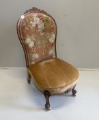 A Victorian walnut spoon back nursing chair, retaining original floral tapestry to back, width 50cm,