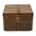 A vintage Louis Vuitton trunk in monogram canvas with brass mounted wooden protection slats and