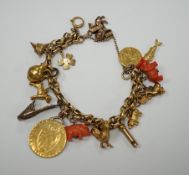 An early 20th century 9ct multi link charm bracelet, hung with sixteen assorted charms, including