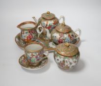 A 19th century Chinese famille rose teaset including a trefoil shaped tray, two teapots, sugar bowl,