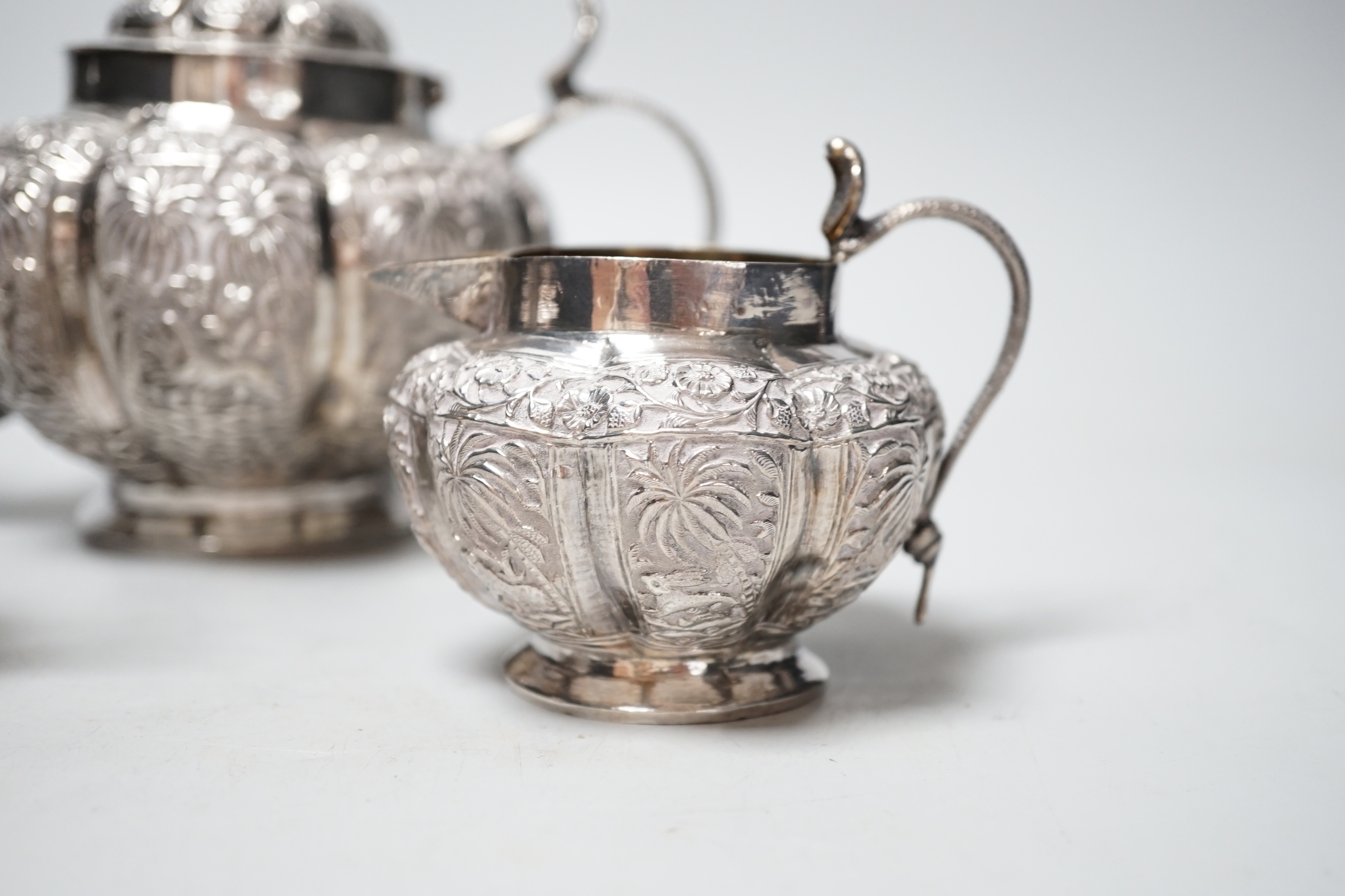 An Indian embossed white metal three piece tea set, with cobra handles and elephant finial, 25. - Image 3 of 5
