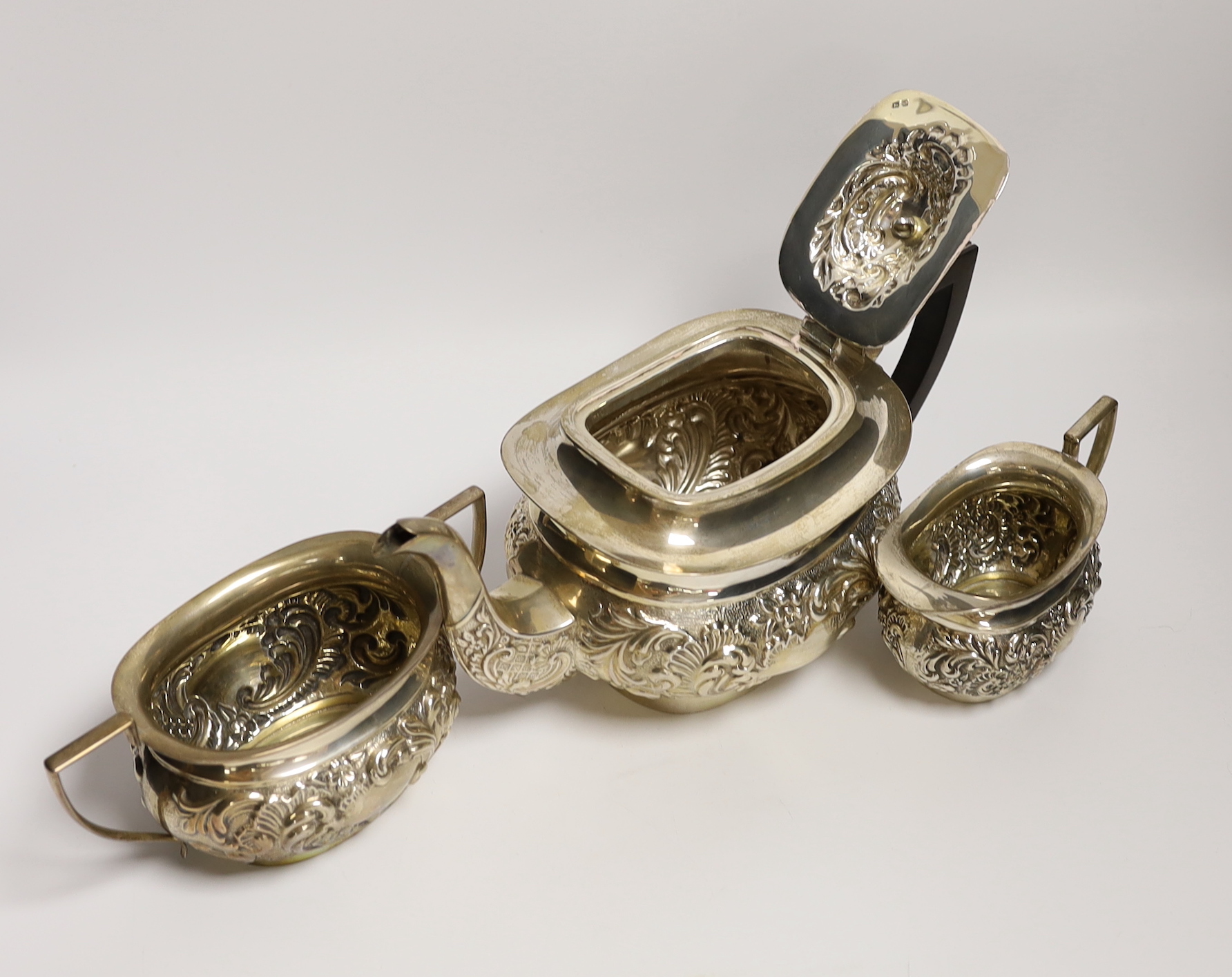 An Edwardian embossed silver three piece tea set, William Devonport, Birmingham, 1909, gross - Image 2 of 3