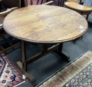 A 19th century French oval oak and pine tilt top folding table, width 90cm, depth 100cm, height