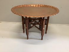 A Moorish circular copper tray top occasional table on folding stand, diameter 77cm, height 53cm***