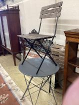 A painted wrought iron circular garden table, diameter 59cm, height 72cm and two slatted folding