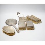 A George V silver mounted hand mirror, Birmingham, 1916, five assorted silver mounted brushes